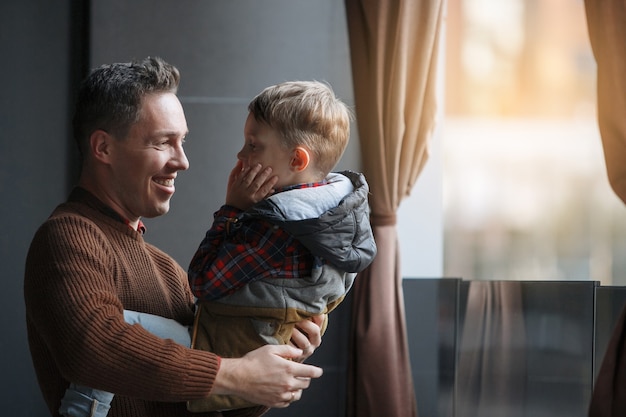 Foto il padre tiene il figlio tra le braccia. amore dei genitori, infanzia felice, cura dei bambini.