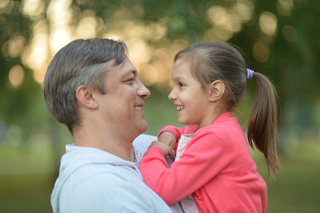 Father hugging his little daughter in nature