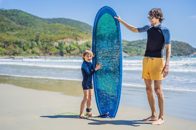 Father or instructor teaching his son how to surf in the sea on vacation or holiday travel and