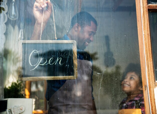 Photo father and kid hangin open sign