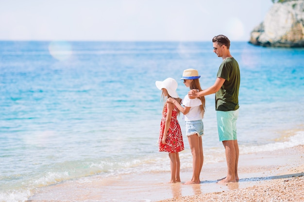 父と子供たちはビーチの夏休みを楽しんで