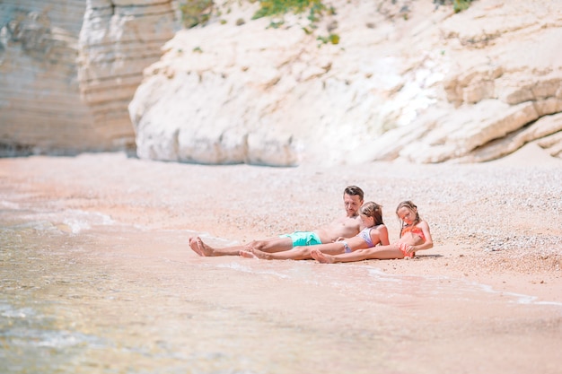 Padre e bambini che godono le vacanze estive della spiaggia