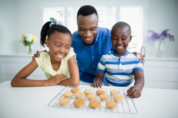 父とテーブルの上のクッキーを見て子供たち