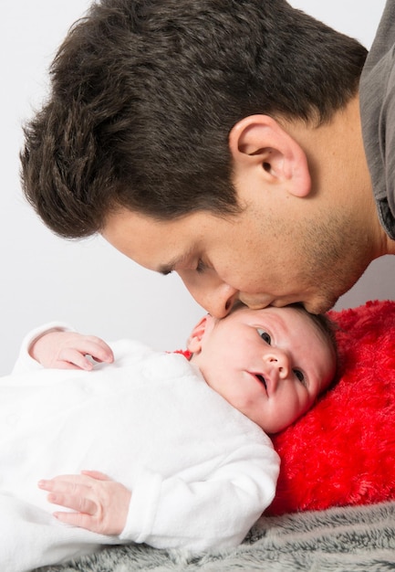 Father kissing his new born baby  forehead