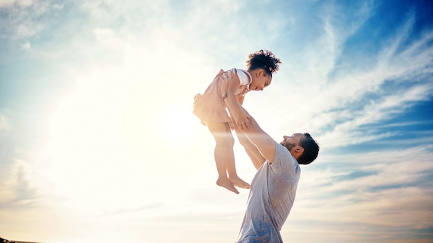家族旅行と自由な屋外の絆と海で子供を持ち上げる父と男と幸せな人々の太陽の光と熱帯の休暇の子供がお父さんと冒険と一緒に飛ぶ