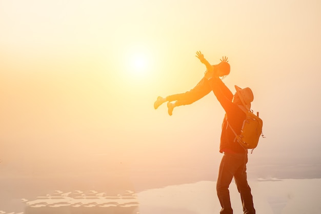 Father and little girl playing on the beach at the sunset