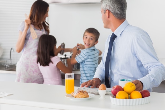 Father looking at his family cooking in the kitchen 