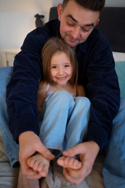 Foto padre che fa ridere sua figlia facendole il solletico