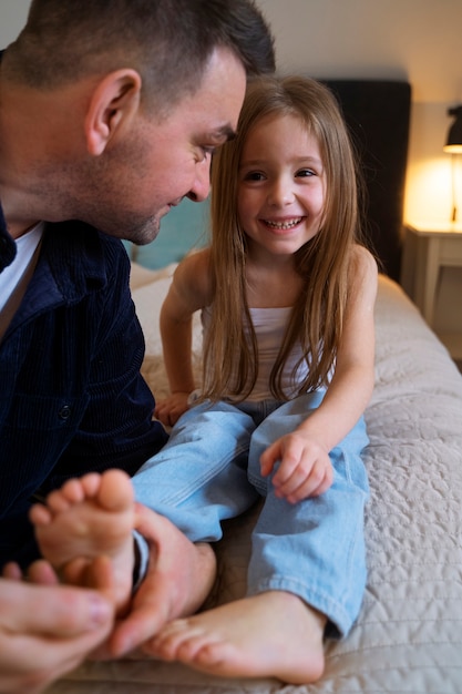 Foto padre che fa ridere sua figlia facendole il solletico