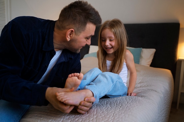 Foto padre che fa ridere sua figlia facendole il solletico