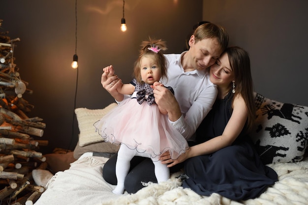 Father mom and their little one year old daughter have fun together before christmas