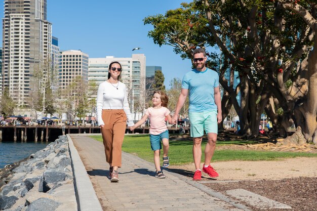 Father mother and child in park friendly family having fun in summer young parents with kid boy mom dad and son love relax together adoption and charity family day friendship