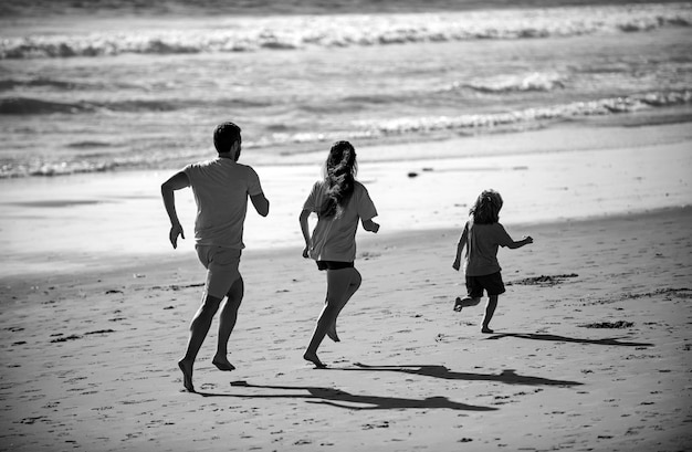 Foto padre madre e figlio in corsa jogging sulla spiaggia concetto di stile di vita di famiglia sano persone d'estate