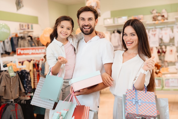 Father, mother and daughter are in clothes store