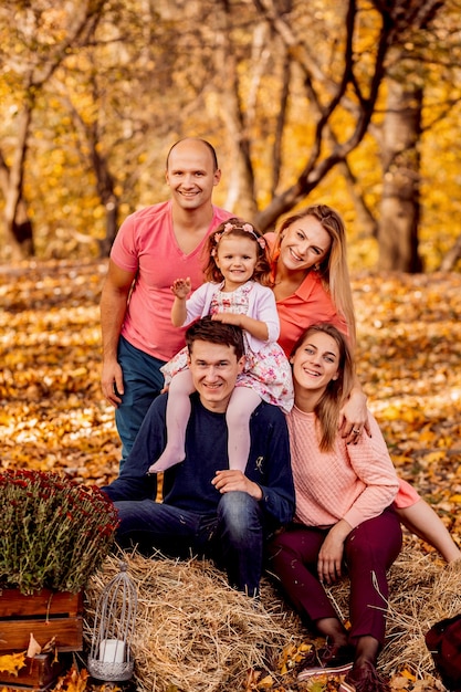 Photo the father,mother,daughter and friends sitting on the hays