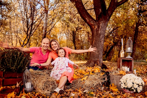 The father,mother and daughter sitting on the hays