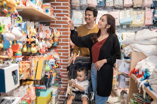 Padre e madre fanno la spesa al baby shop con il figlio nel passeggino
