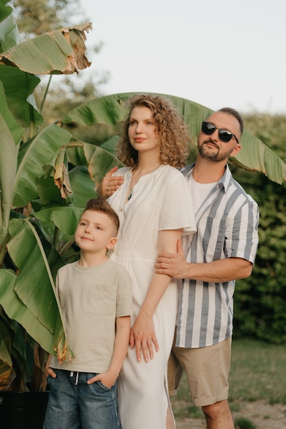 Father mother and son are having fun with palm trees in the background