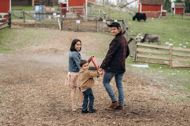 Отец, мать и сын в повседневной одежде позируют в сельской местности