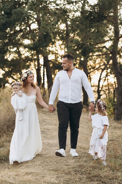 Father, mother and two children daughters spending time and playing in nature