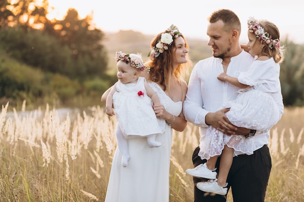 Photo father, mother and two children daughters spending time and playing in nature