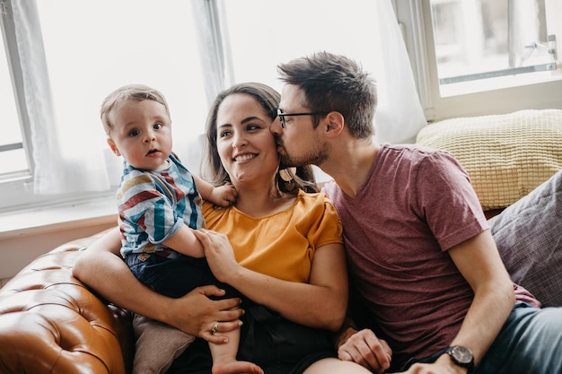 Photo father and mother with son sitting on sofa at home