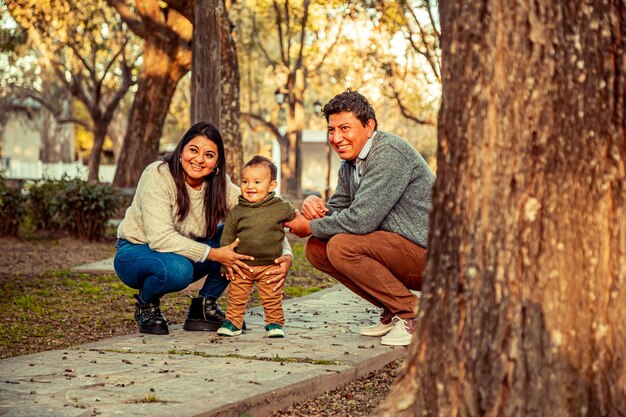 Father and mother with their little son in a park outdoors