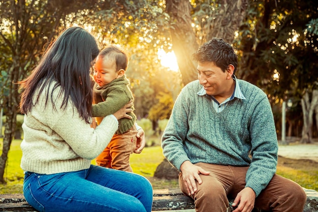 Father and mother with their little son in a park outdoors