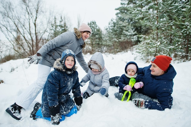 雪の中で冬の自然の屋外で 3 人の子供を持つ父と母