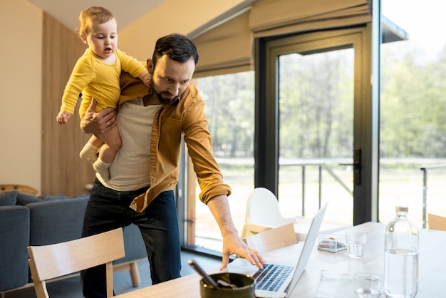 Father nursing his baby son and works from home