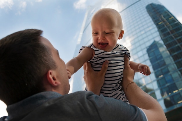 Father and one year old daughter against the sky and skyscrapers. Travel with children, the development of emotional intelligence.