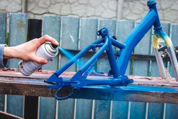 Father paints a bicycle for a child