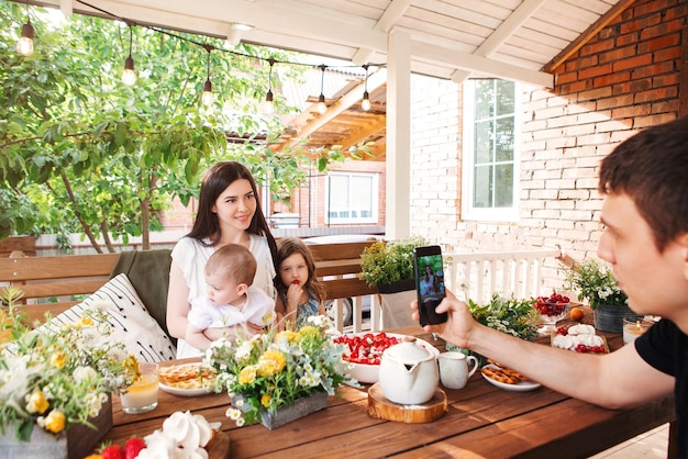 Father photographing family members at dining table