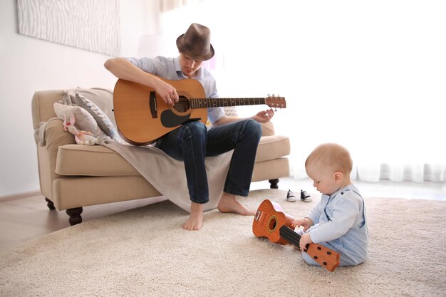 Father playing guitar to his son