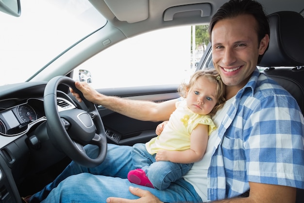 Father playing with baby in drivers seat