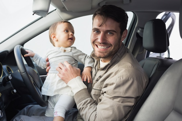 Father playing with baby in drivers seat