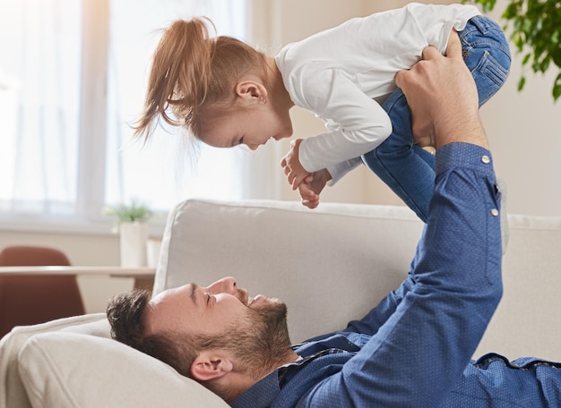 Father playing with daughter at home