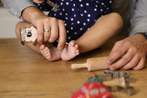 写真 子供の足で遊ぶ父親