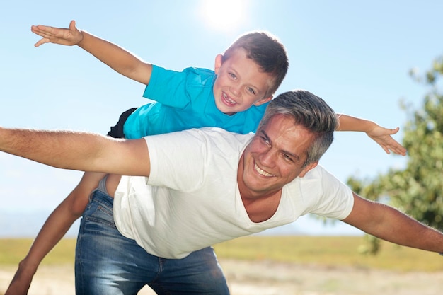 Photo father playing with son outdoors