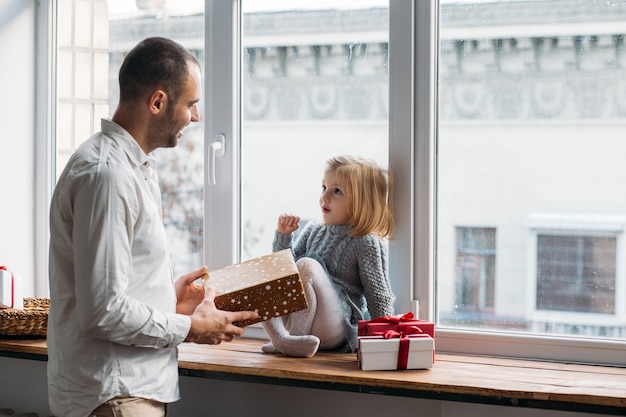 Father present her daughter gift box on Christmas at home