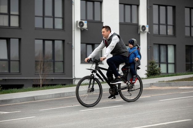 Father riding bike with son in bike seat