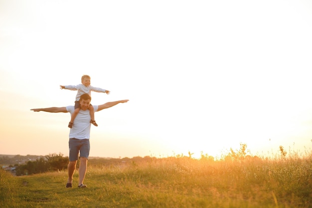 father's day Dad and son playing together outdoors on a summer Happy family father son at sunset