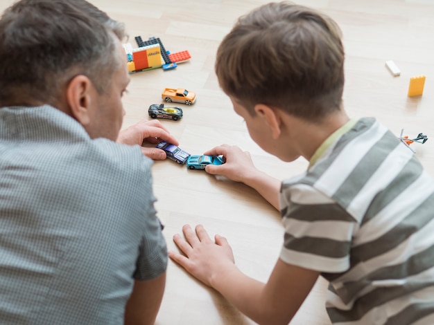 Foto festa del papà papà e figlio che giocano con le automobili sul pavimento