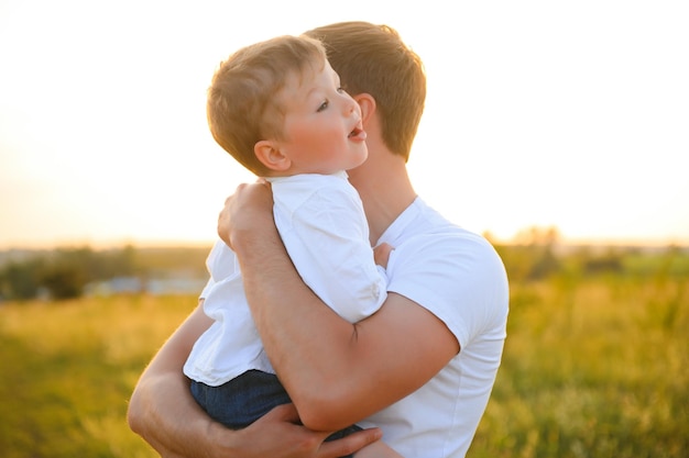 Father's day Happy family father and toddler son playing and laughing on nature at sunset