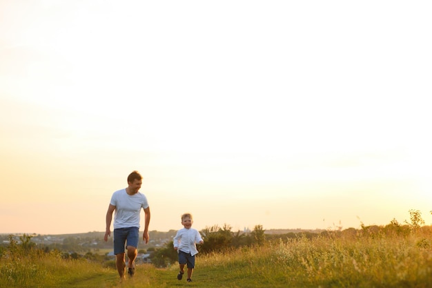 Father's day Happy family father and toddler son playing and laughing on nature at sunset