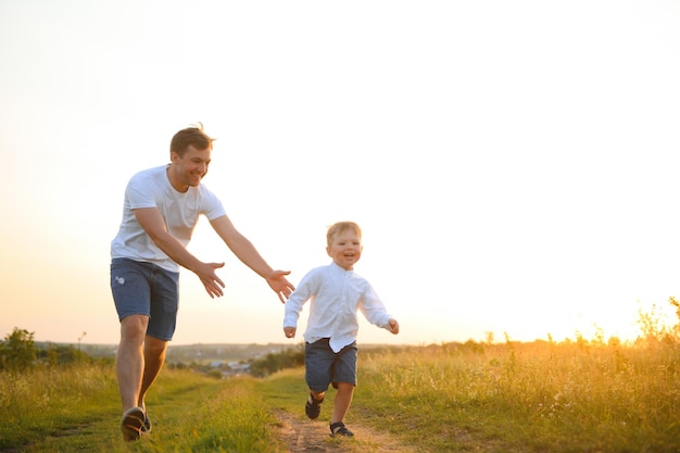 Father's day Happy family father and toddler son playing and laughing on nature at sunset