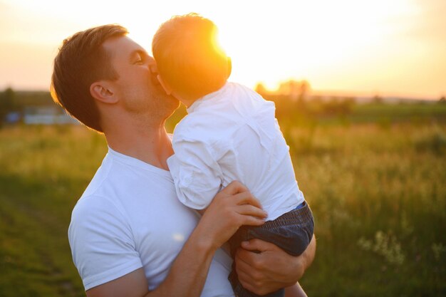 Foto festa del papà padre di famiglia felice e figlio bambino che giocano e ridono sulla natura al tramonto