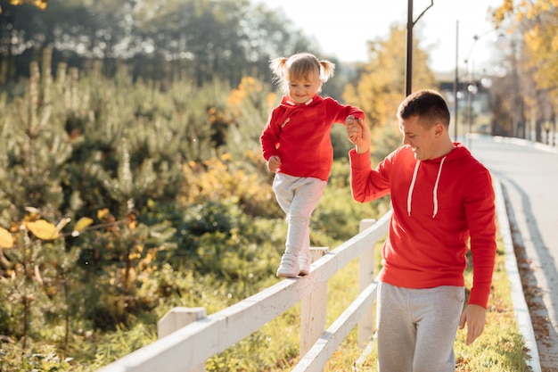 Father's day. Young happy family father and daughter during a walk in the autumn park.