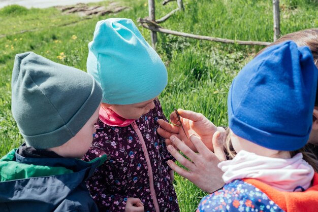 Father shows the children a lizard that he caught in the grass active leisure with children