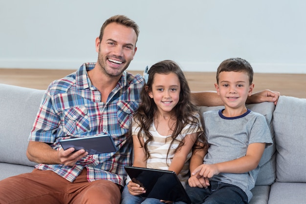 Father and siblings using digital tablet